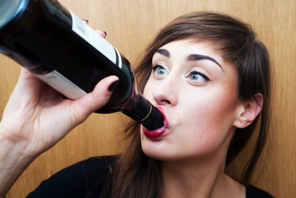 Woman drinking from bottle of wine