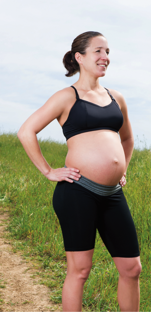 Pregnant woman in sports bra - SuperStock