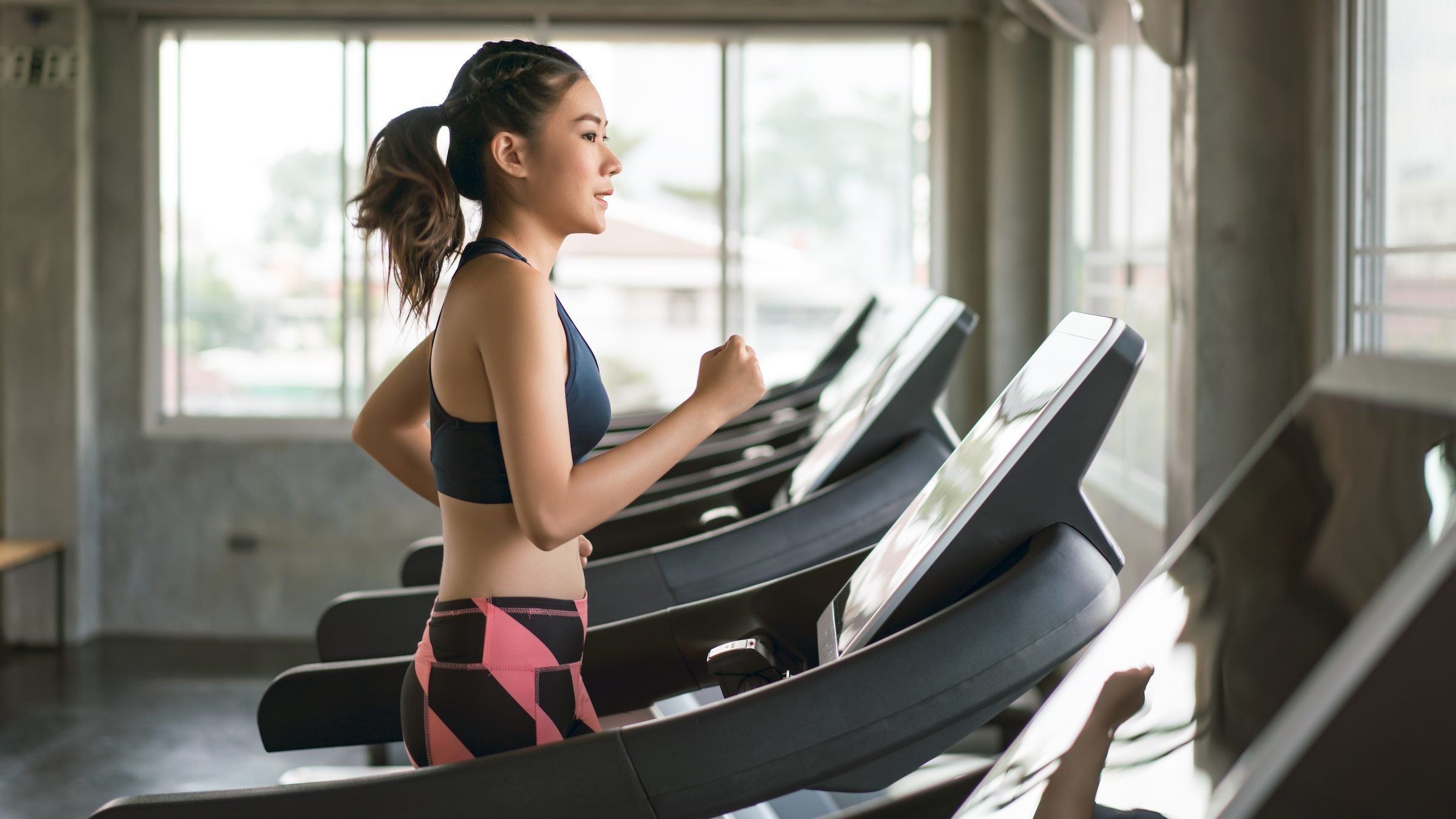Young women in sportswear doing a treadmill workout at gym