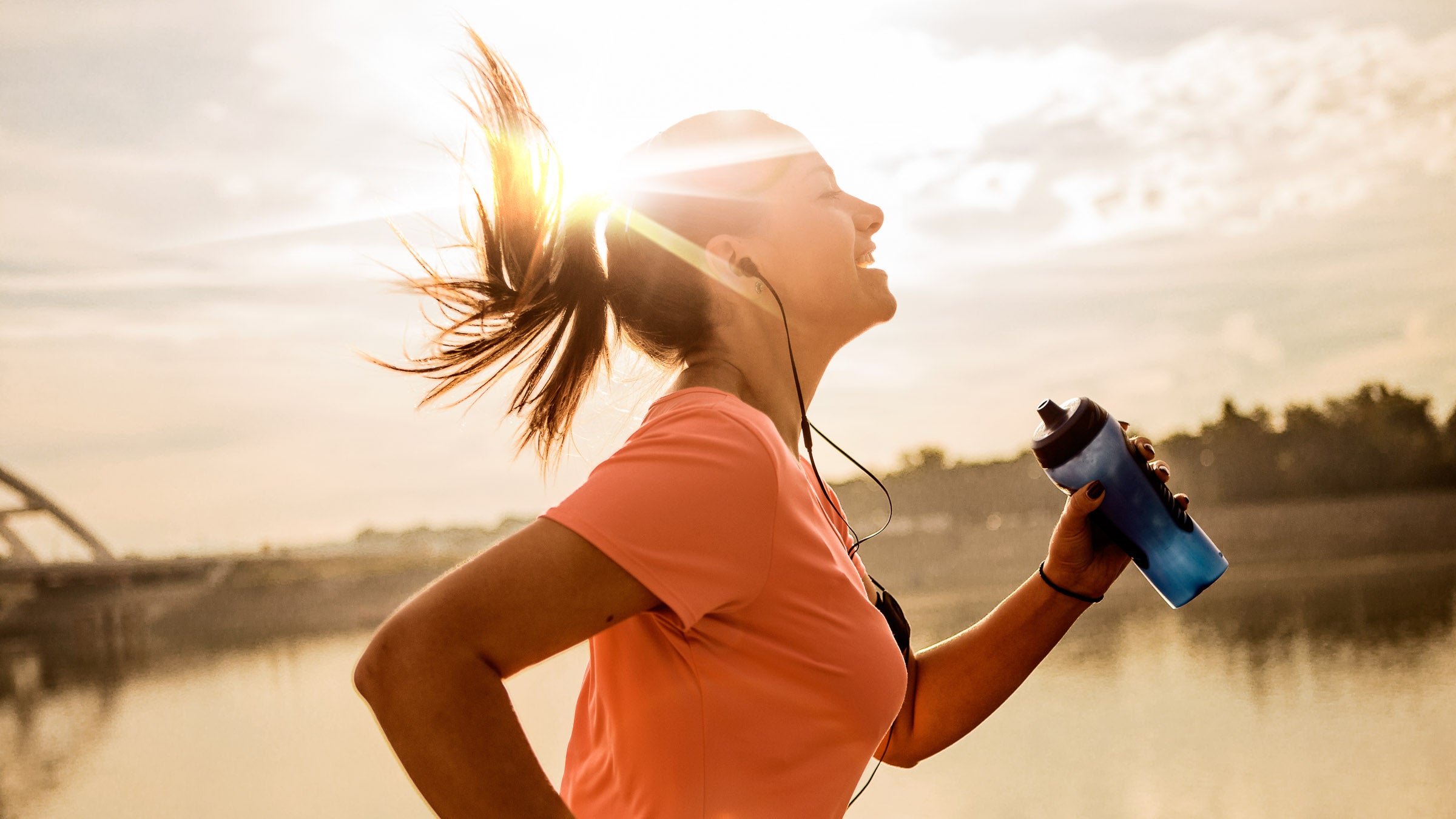 Woman running with water bottle in the morning
