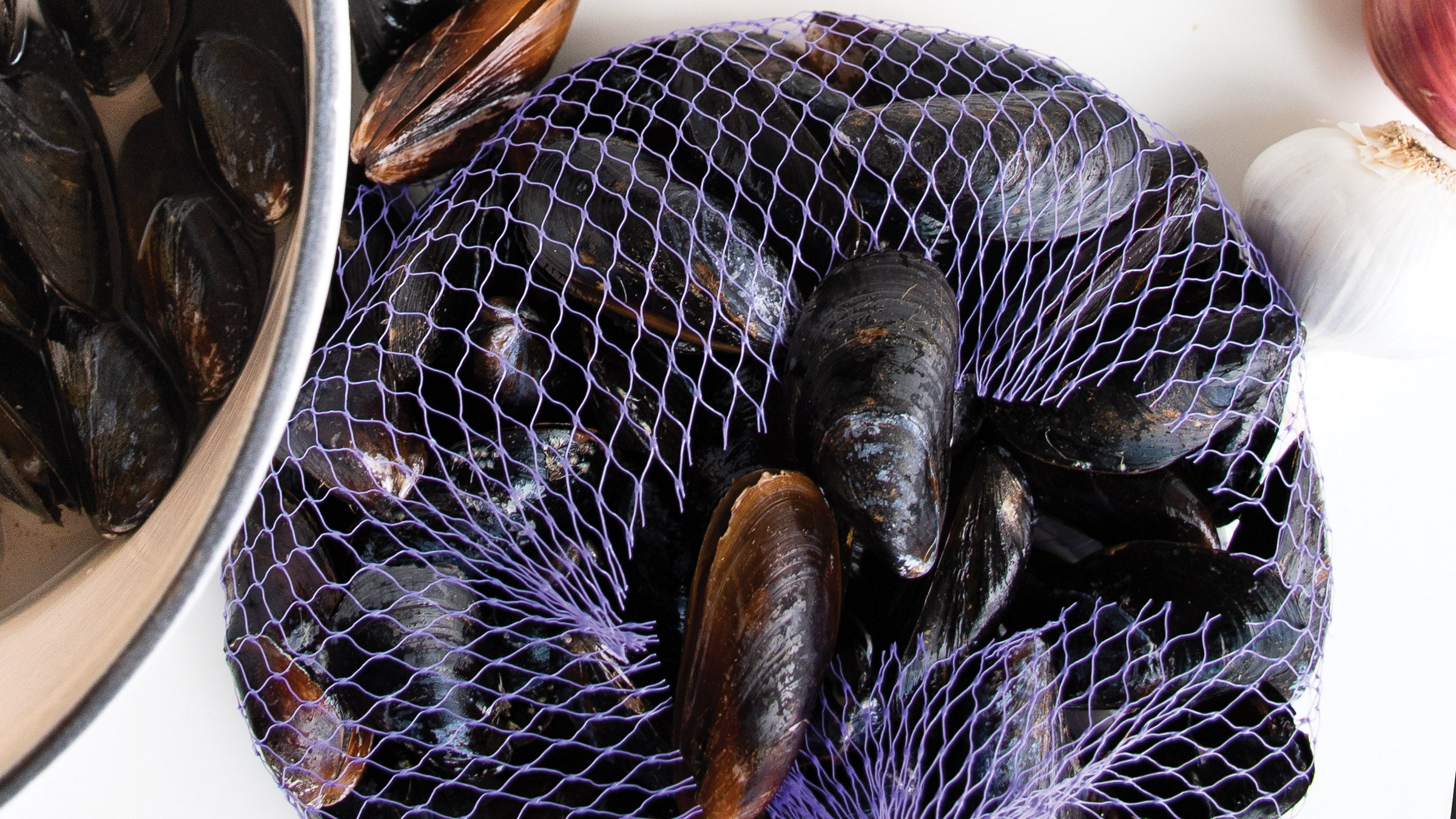 A mesh bag of fresh mussels