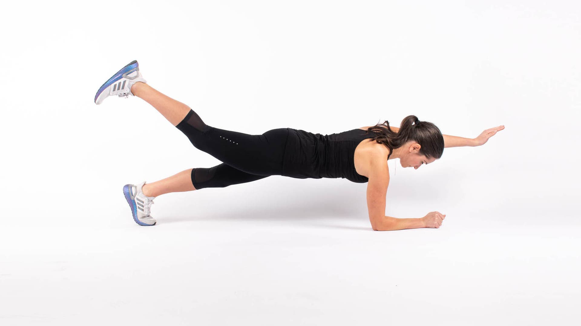 Woman doing isometric core move of a bird dog on forearms