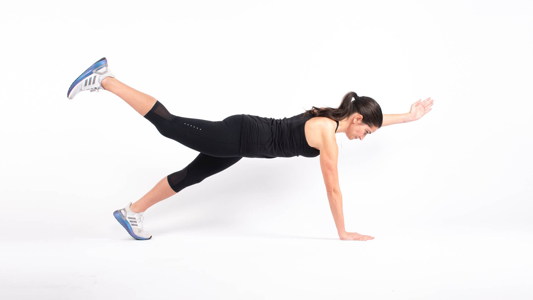 Woman doing bird dog in high plank position