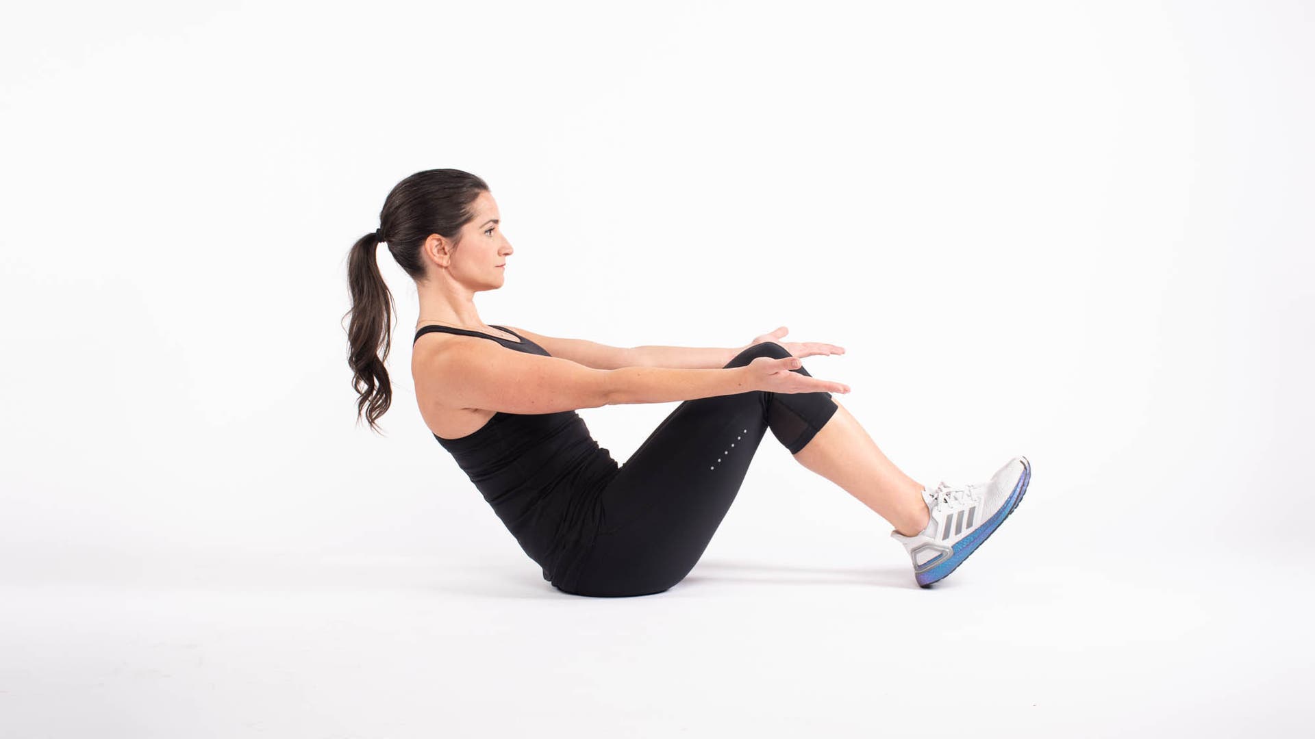 Woman doing boat pose with feet on the floor modification