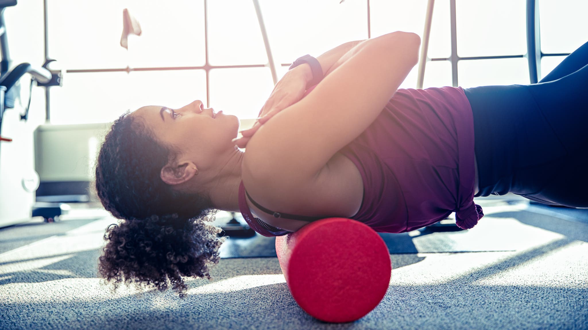 Woman stretching her back with a foam roller