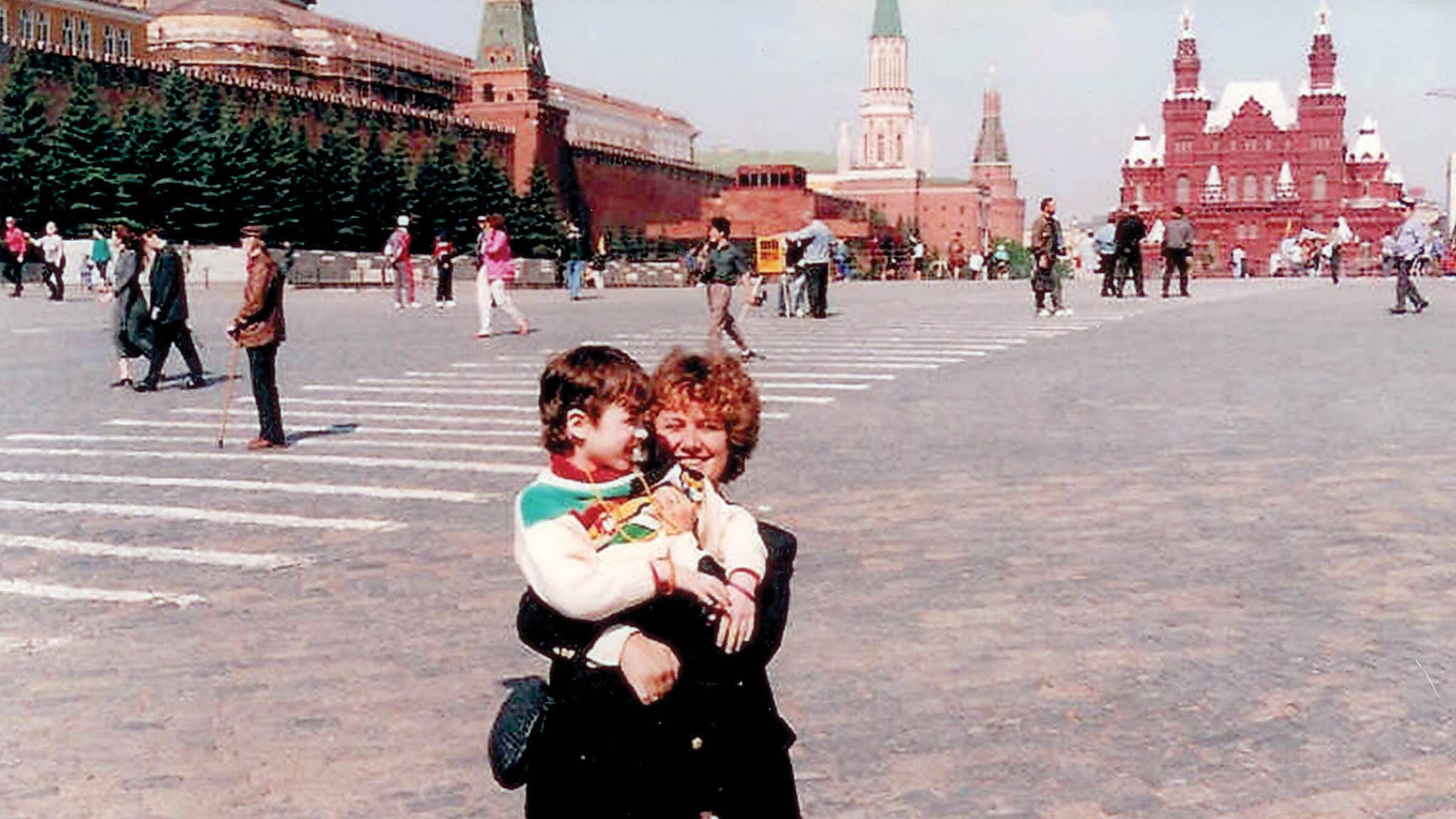 Woman holding a child in an open urban space