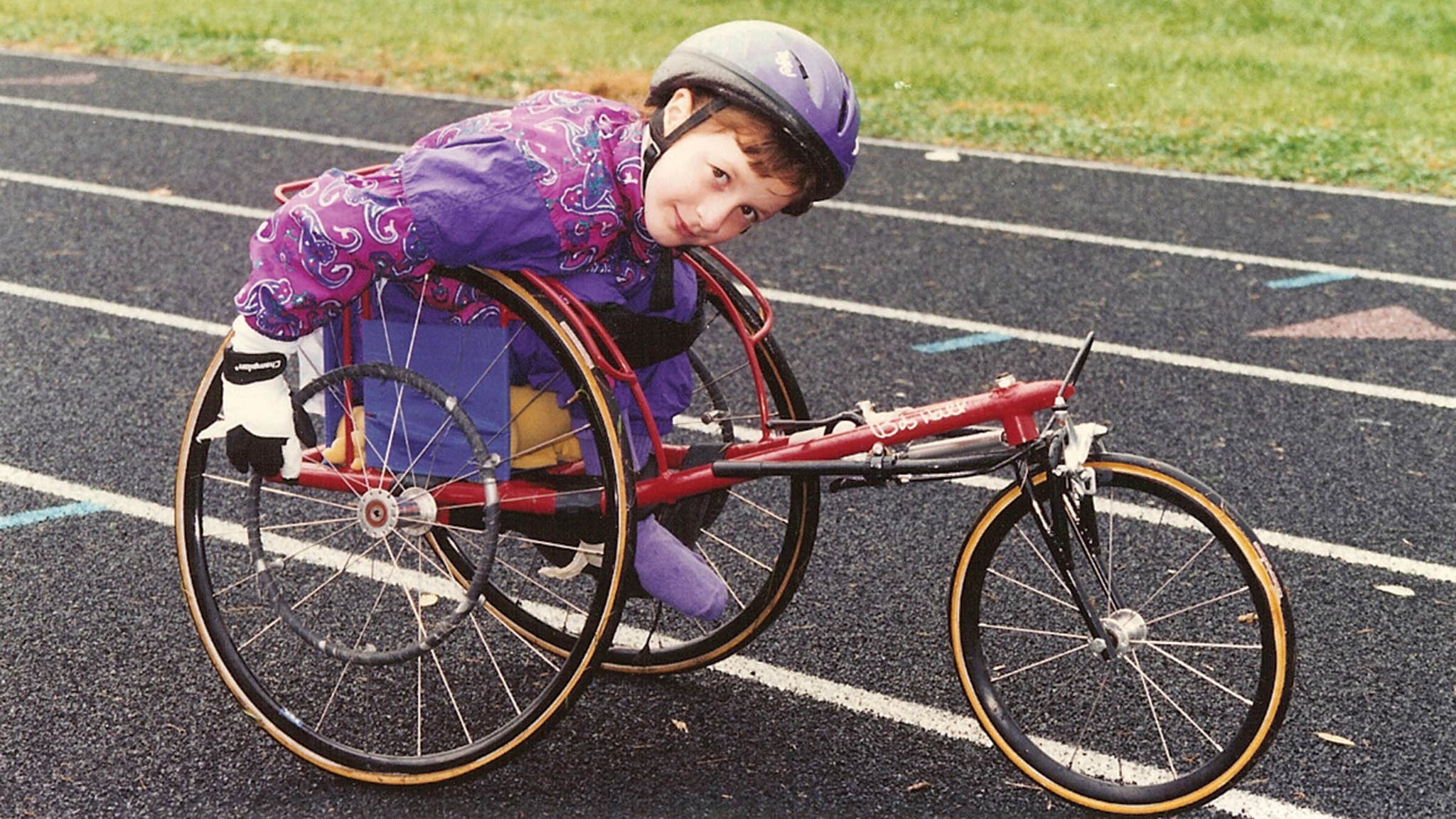 Young McFadden in a racing wheelchair on a running track