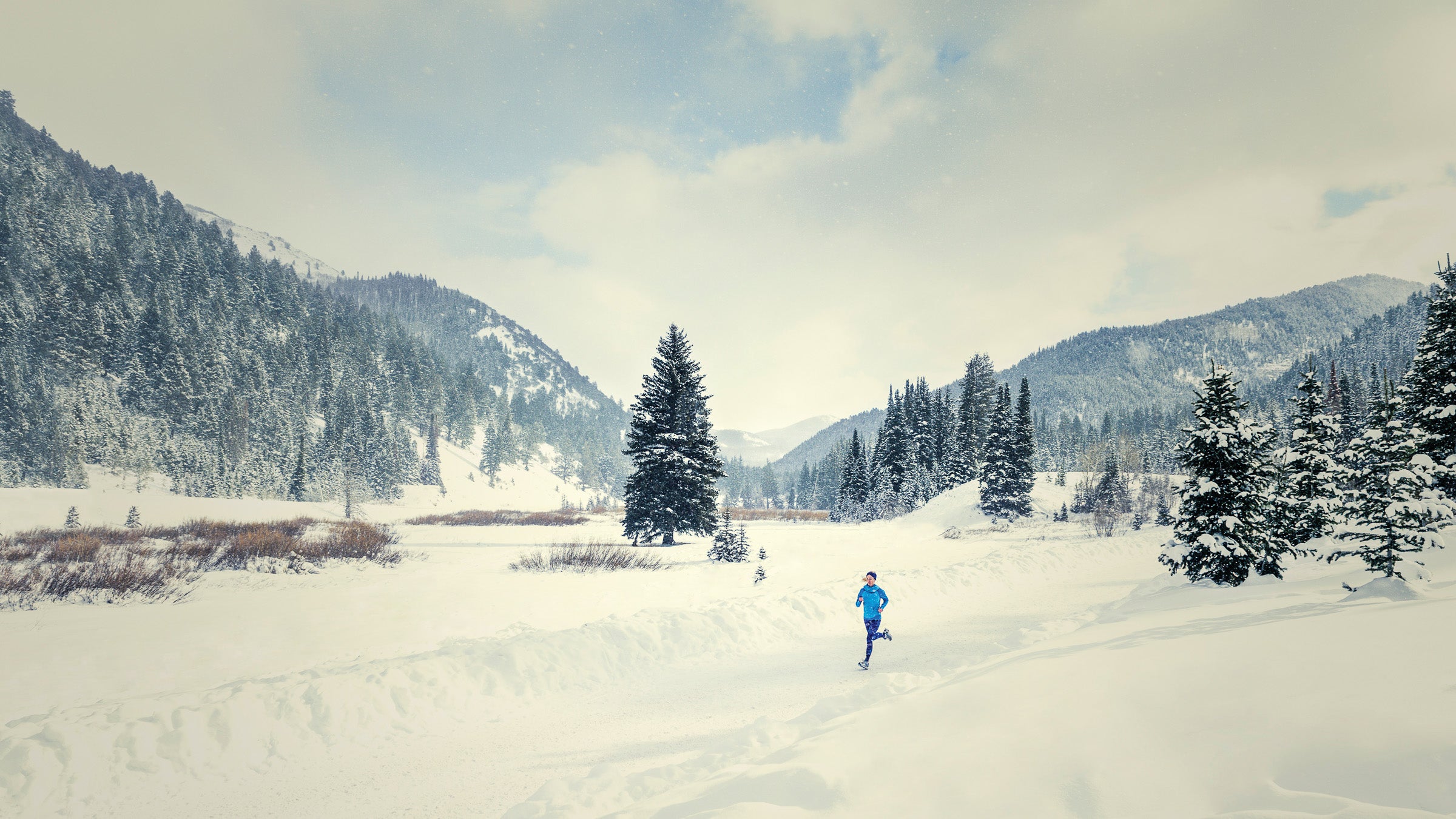 Caucasian woman running in snowy landscape