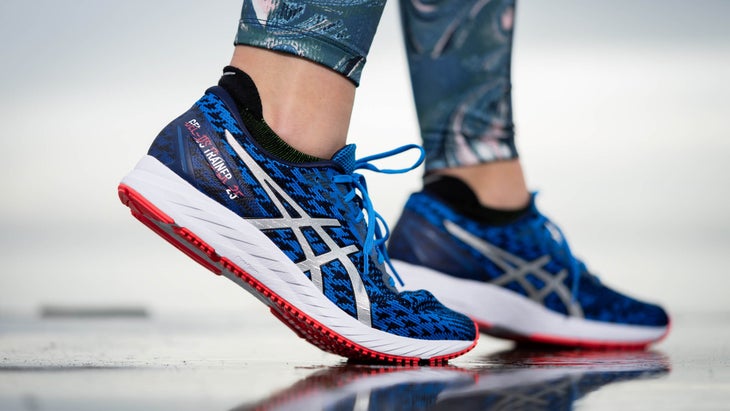 Close up of woman wearing blue Asics on a beach