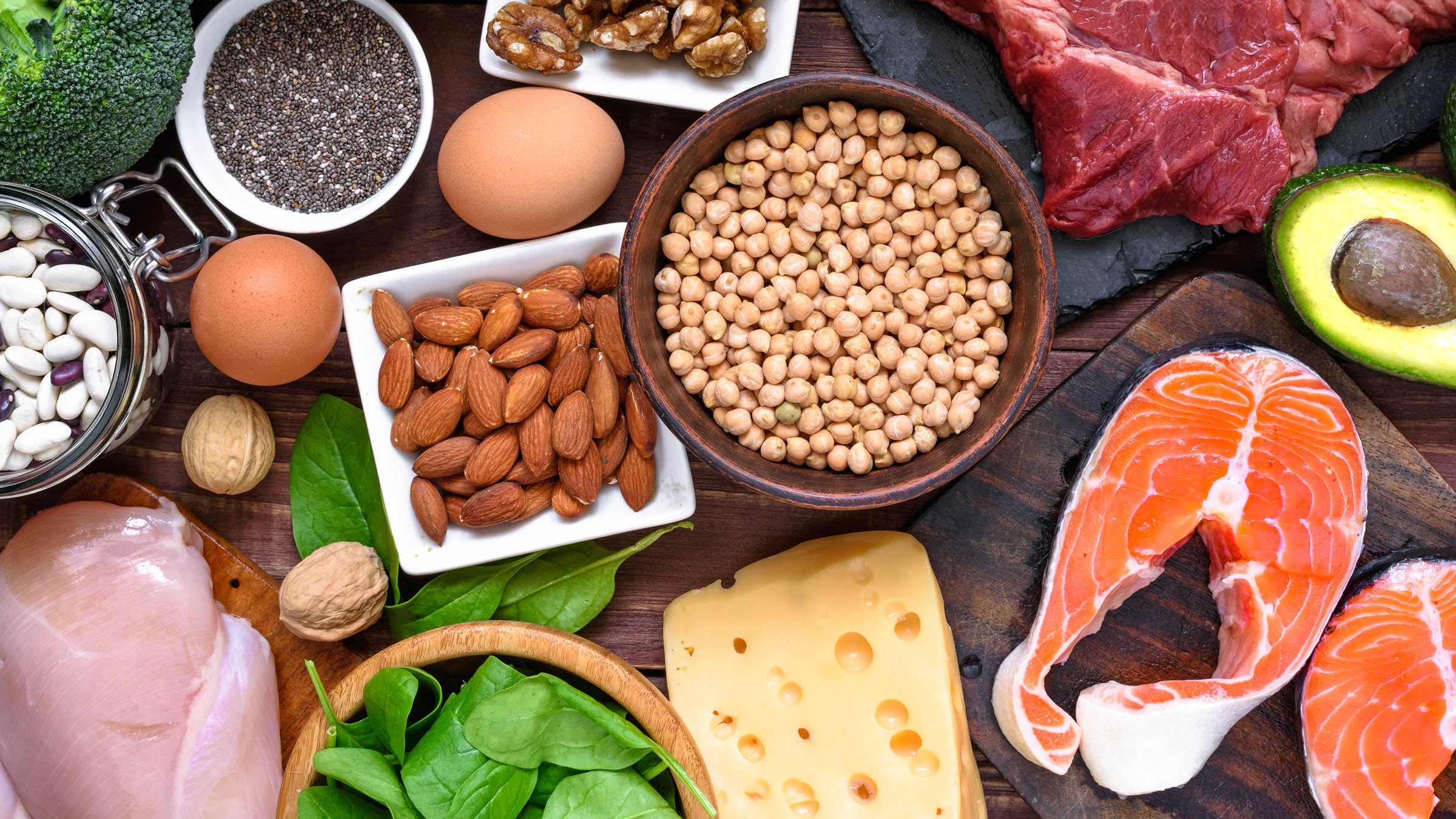 Top view of fish, meat, poultry, nuts, eggs and vegetables on a table