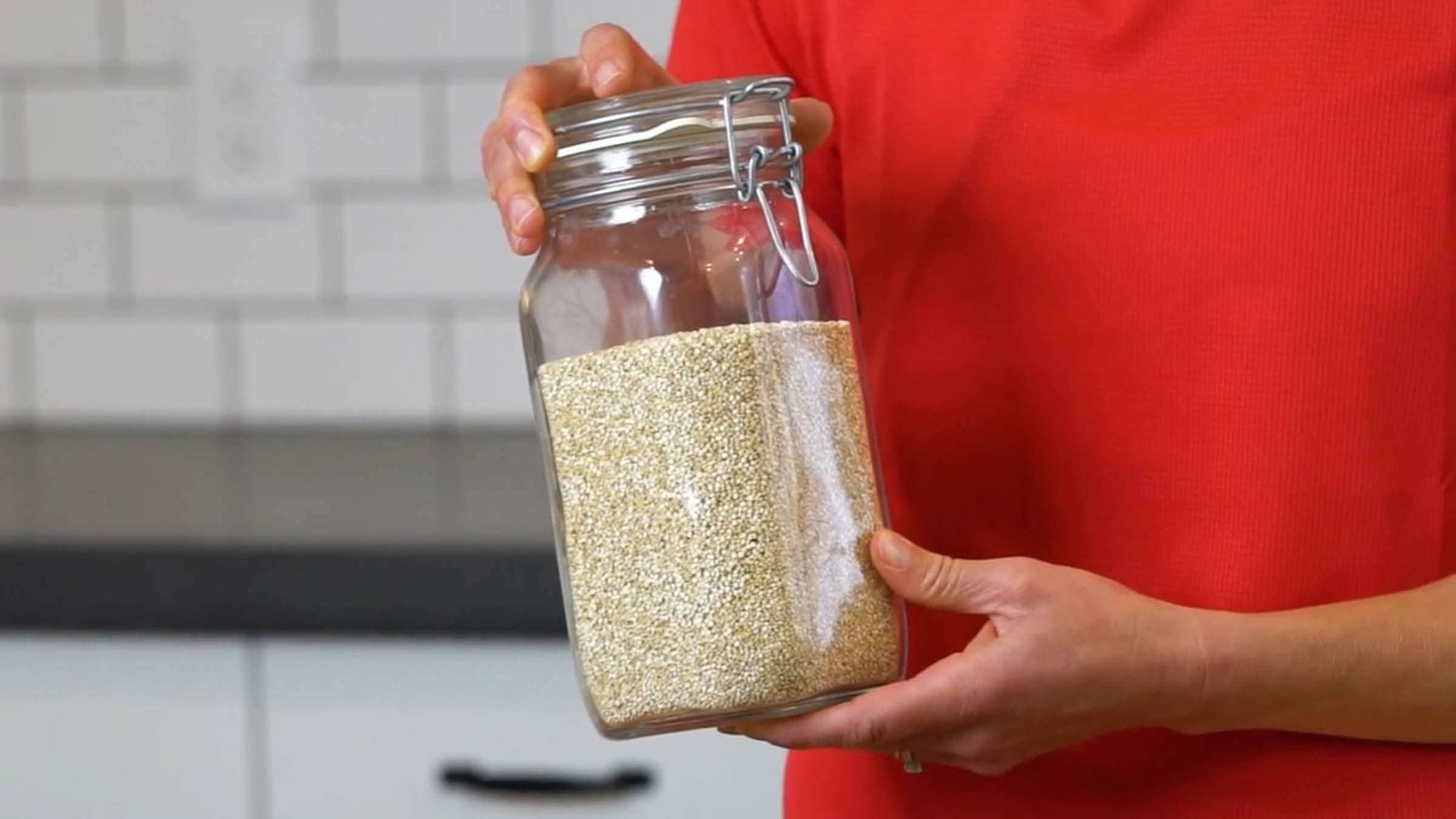 Close up of Elyse holding a jar of grains