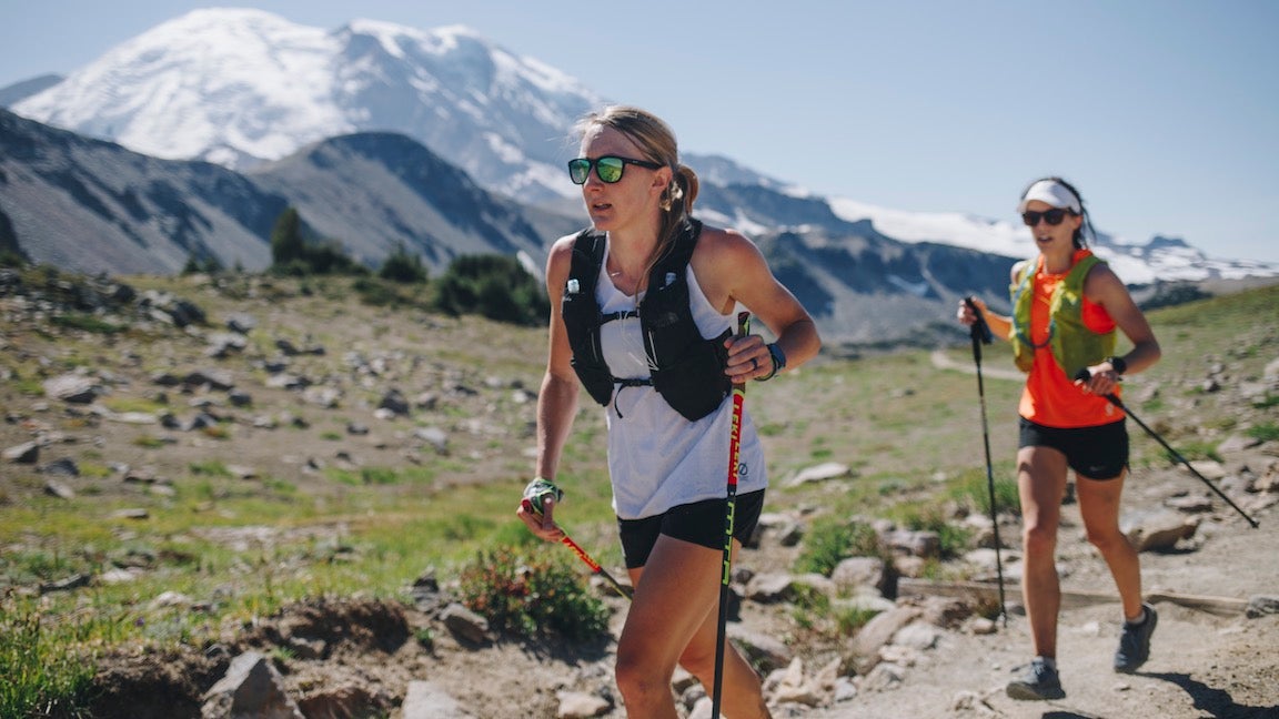 Kaytlyn Gerbin running on trail with mountain in background.