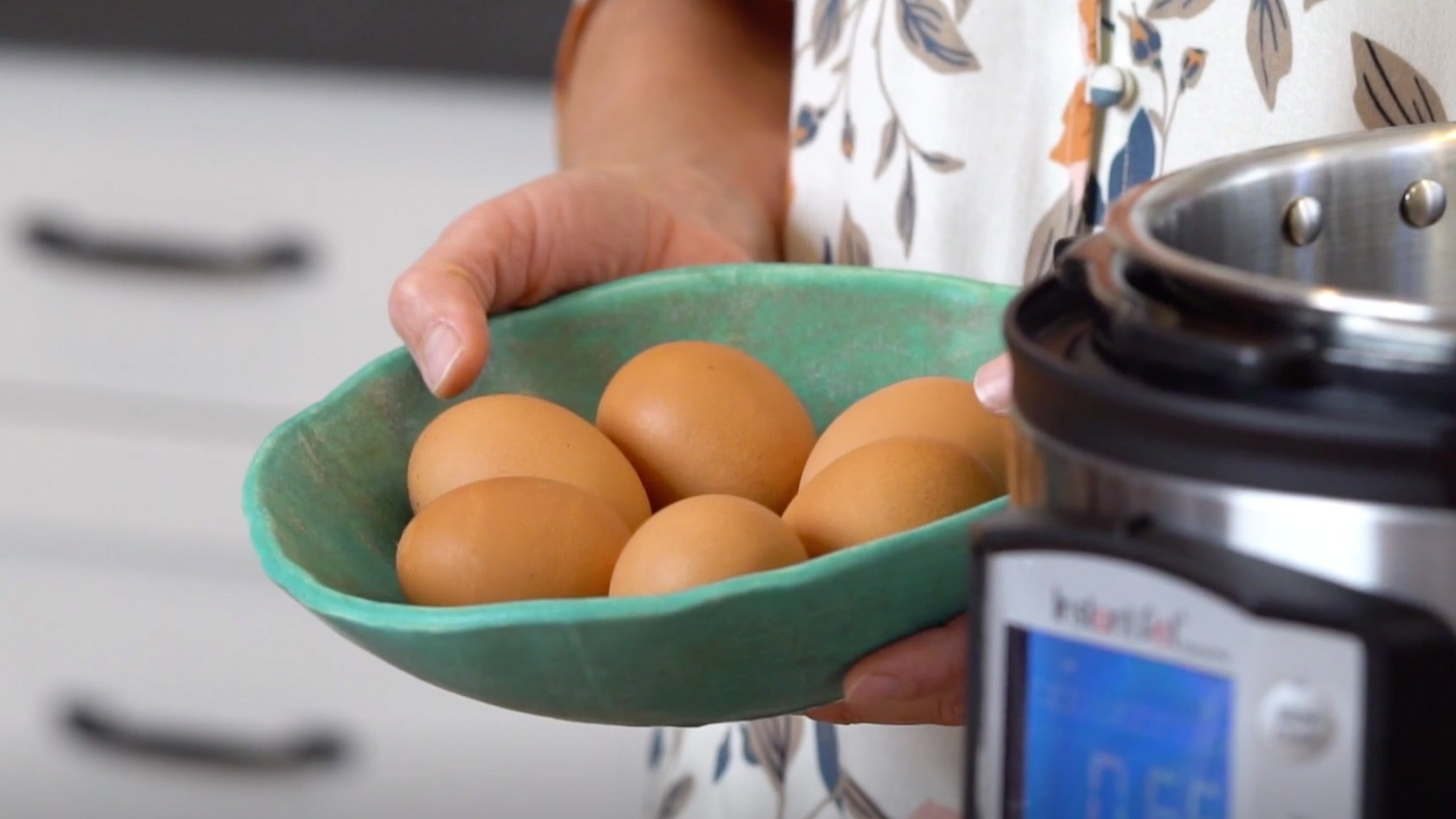Elyse Kopecky holds eggs near an Instant Pot
