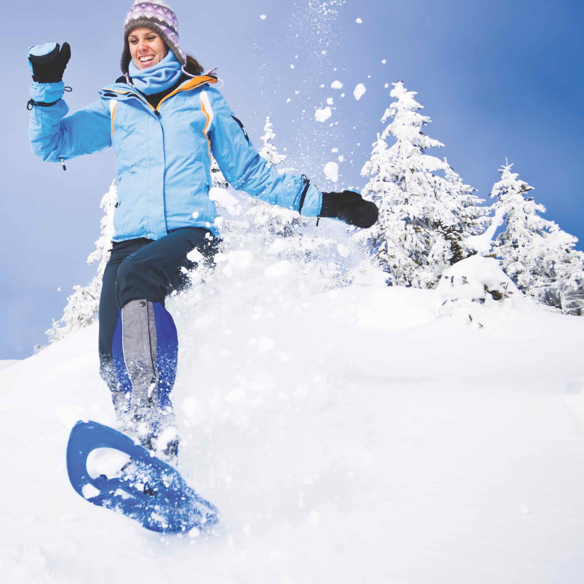 woman smiling while snowshoeing, a great outdoor winter activity for fitness
