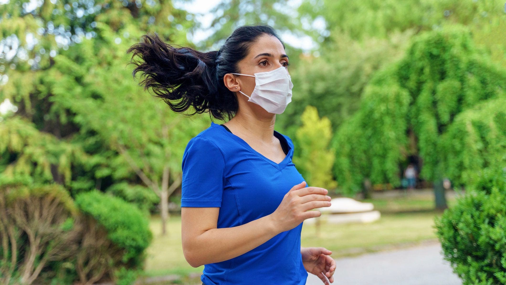 Woman running outdoors with mask