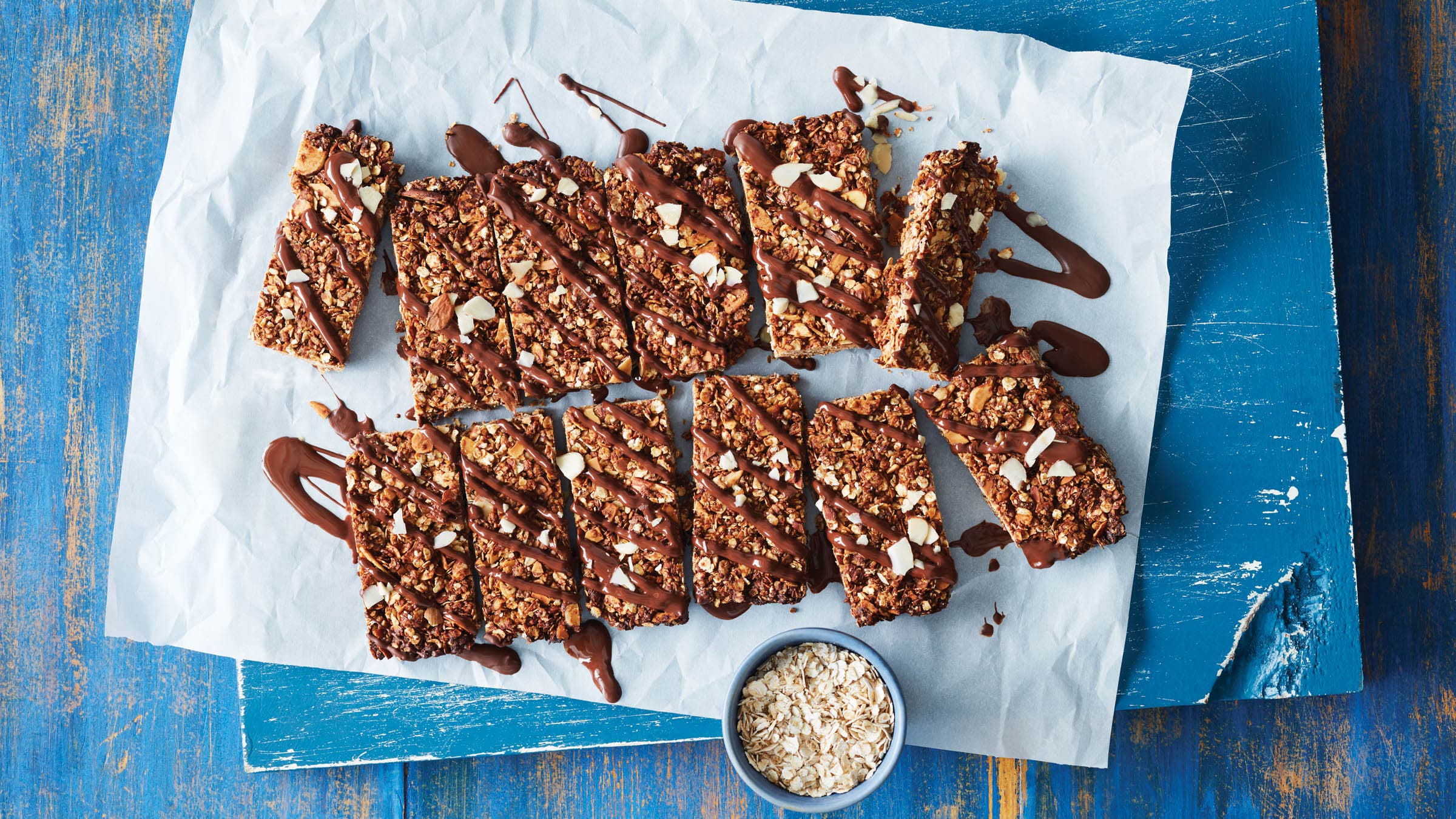 Chocolate Almond Butter Granola Bars on parchment paper with chocolate drizzle make a good breakfast on the go recipe