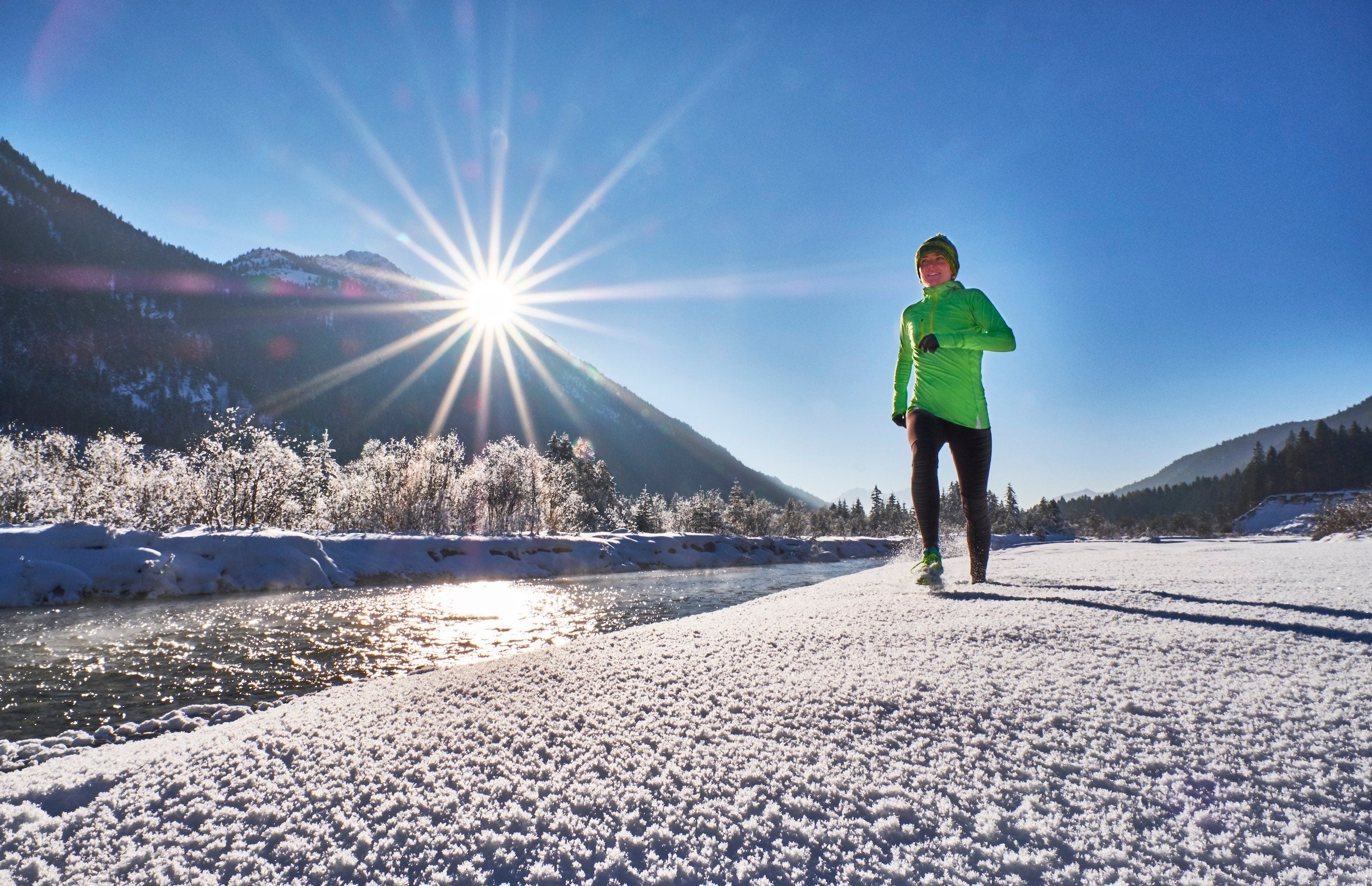 Woman running during a sunny snowy day