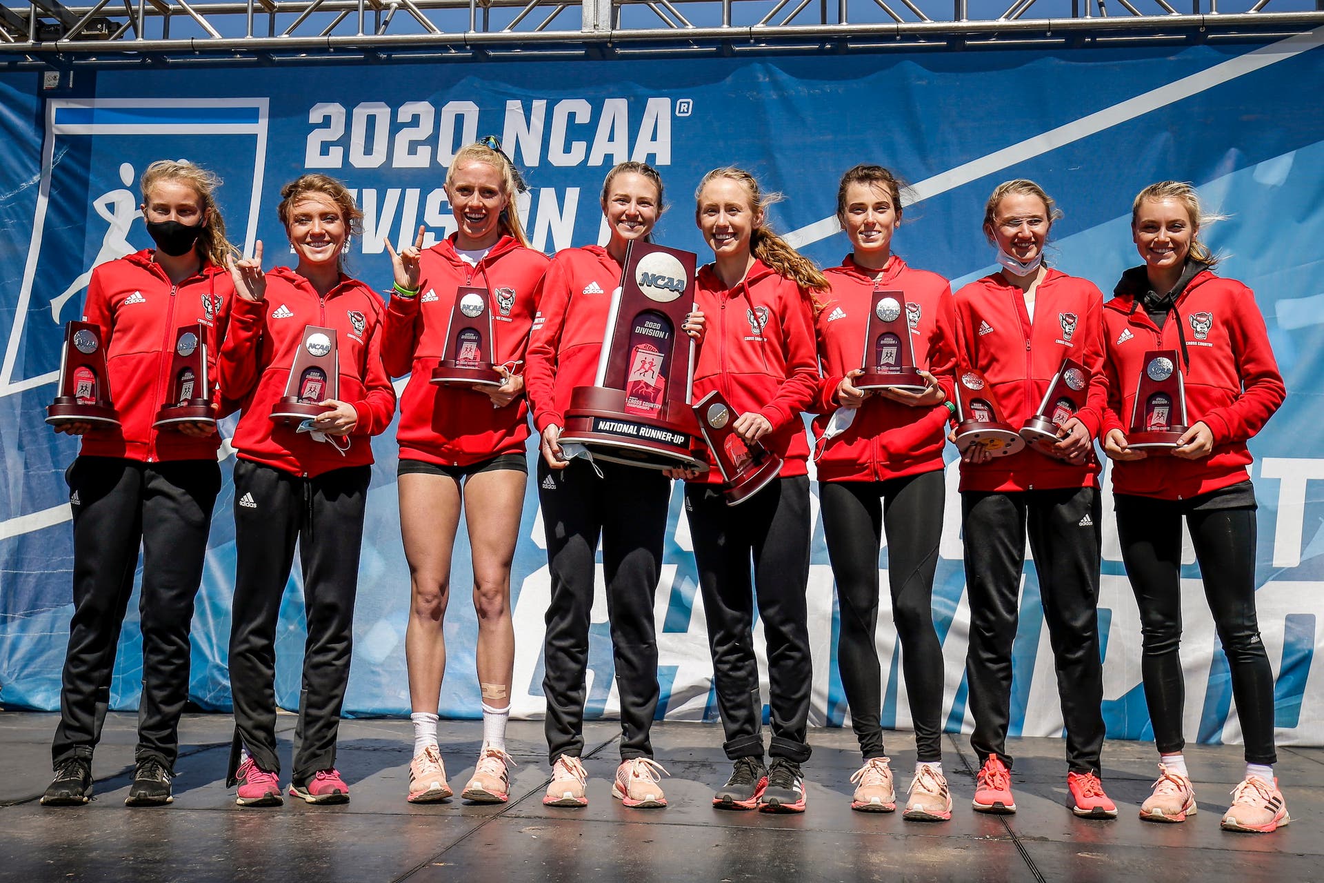 NC State cross-country women's team poses with trophies after placing second at the NCAA track and field cross-country championships