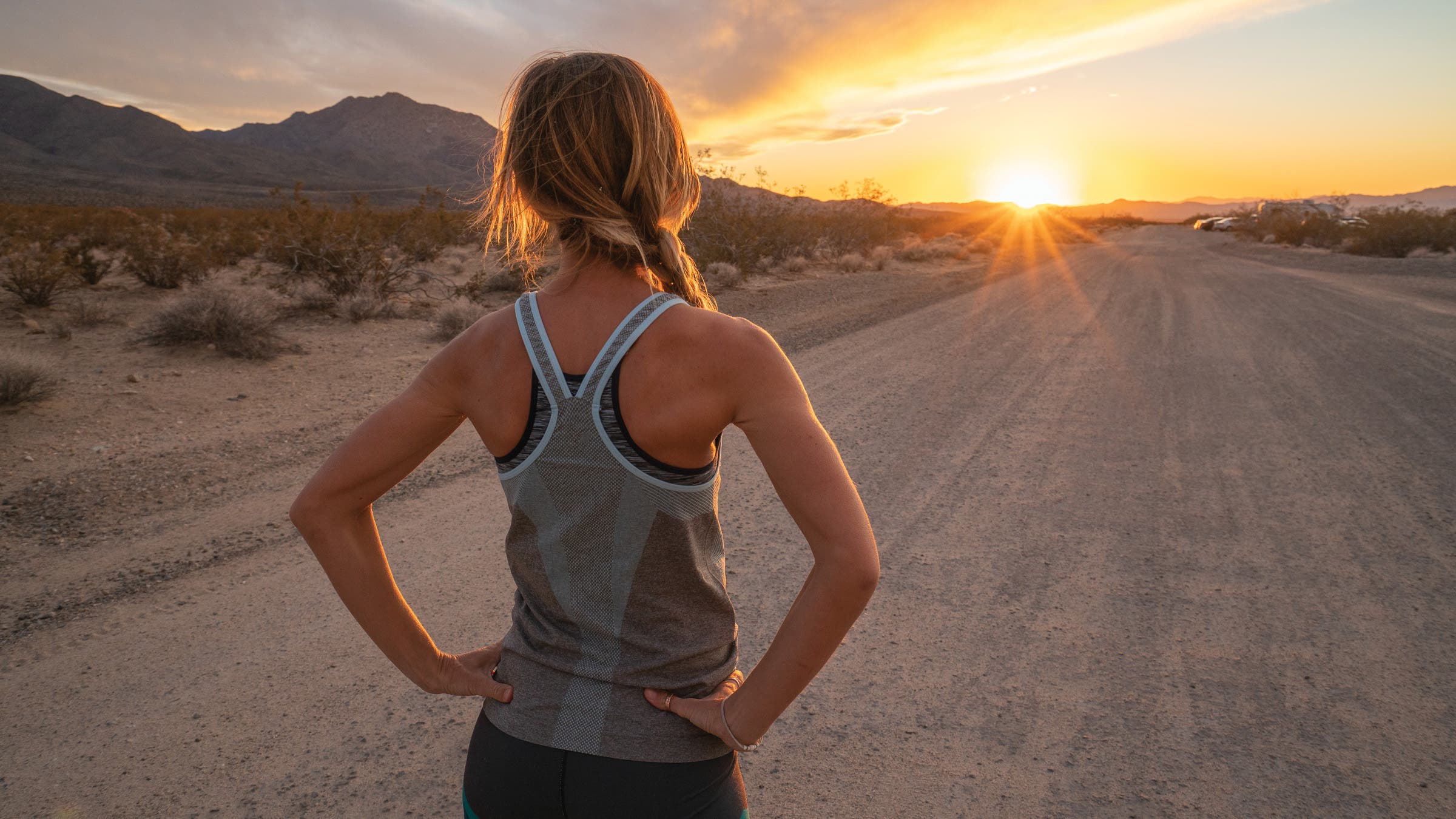 Woman at sunset on the end of the road after running.