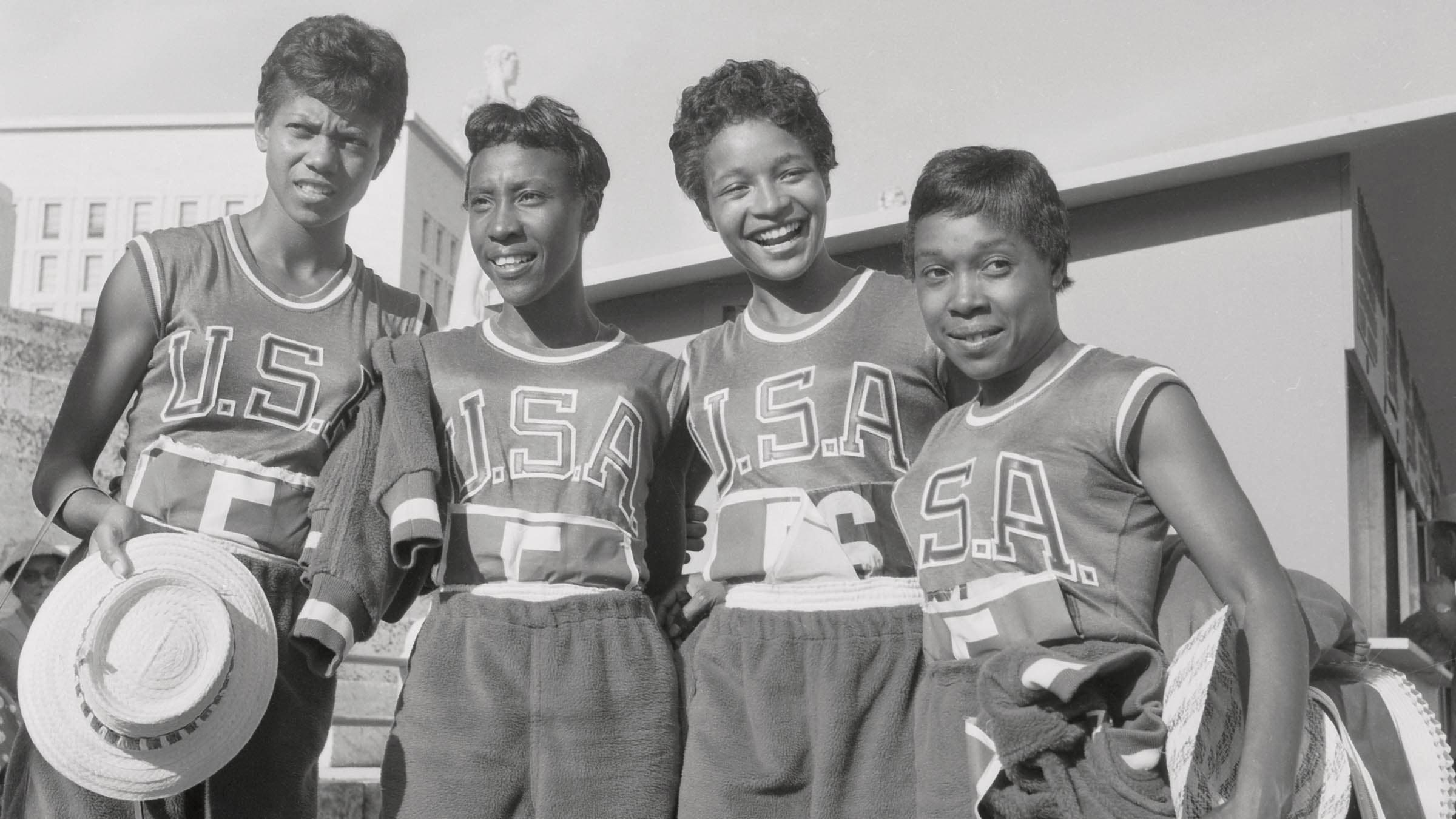 Black and white photo of four women standing together