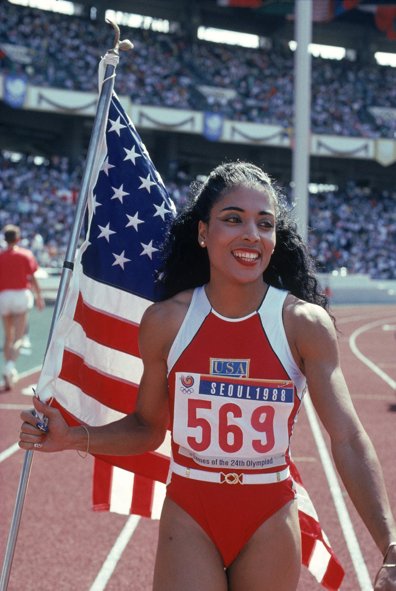 Florence Griffith Joyner of the USA walks with the American Flag
