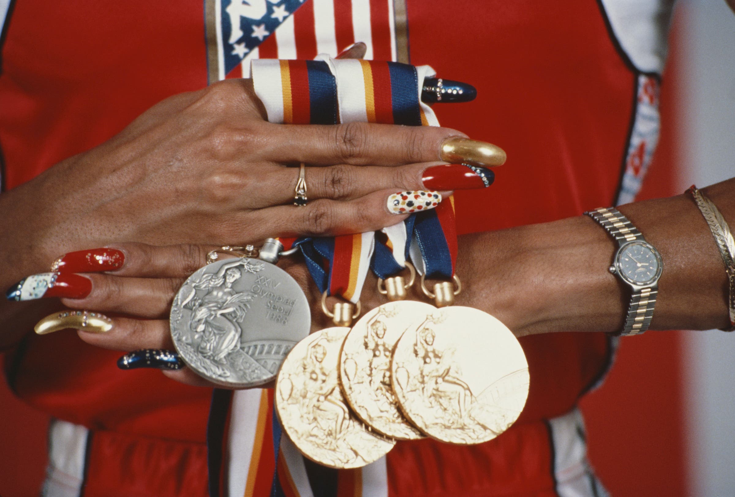 Florence Griffith-Joyner of the USA displays her three gold medals and a silver medal that she won at the 1988 Summer Olympics in Seoul, Korea. Griffith-Joyner won gold medals in the 100m, 200m and the 4x100m relay. Mandatory Credit: Tony Du