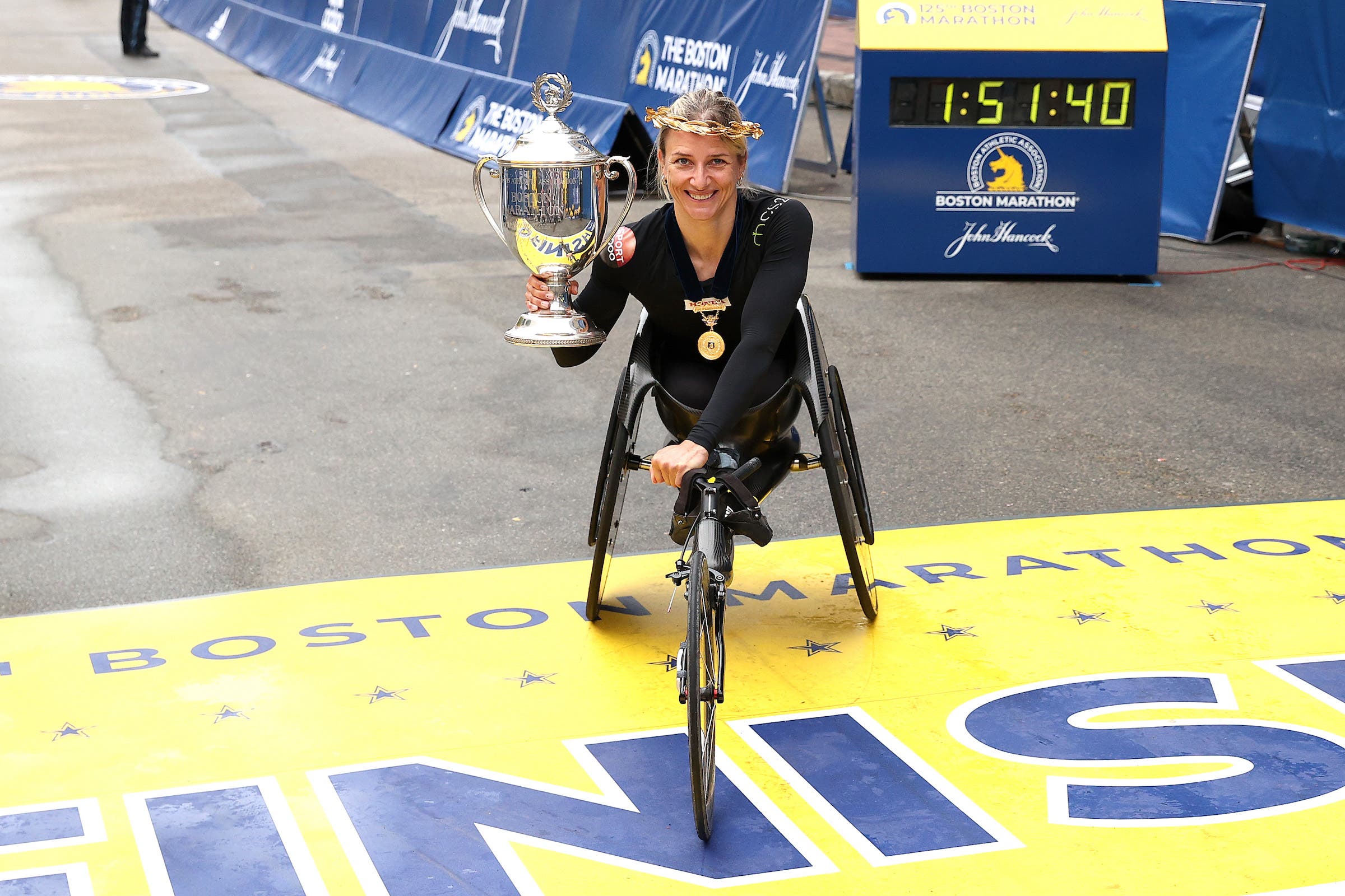 Manuela Schar of Switzerland poses with the Champion's Trophy after winning the women's wheelchair race during the 125th Boston Marathon on October 11, 2021 in Boston, Massachusetts.