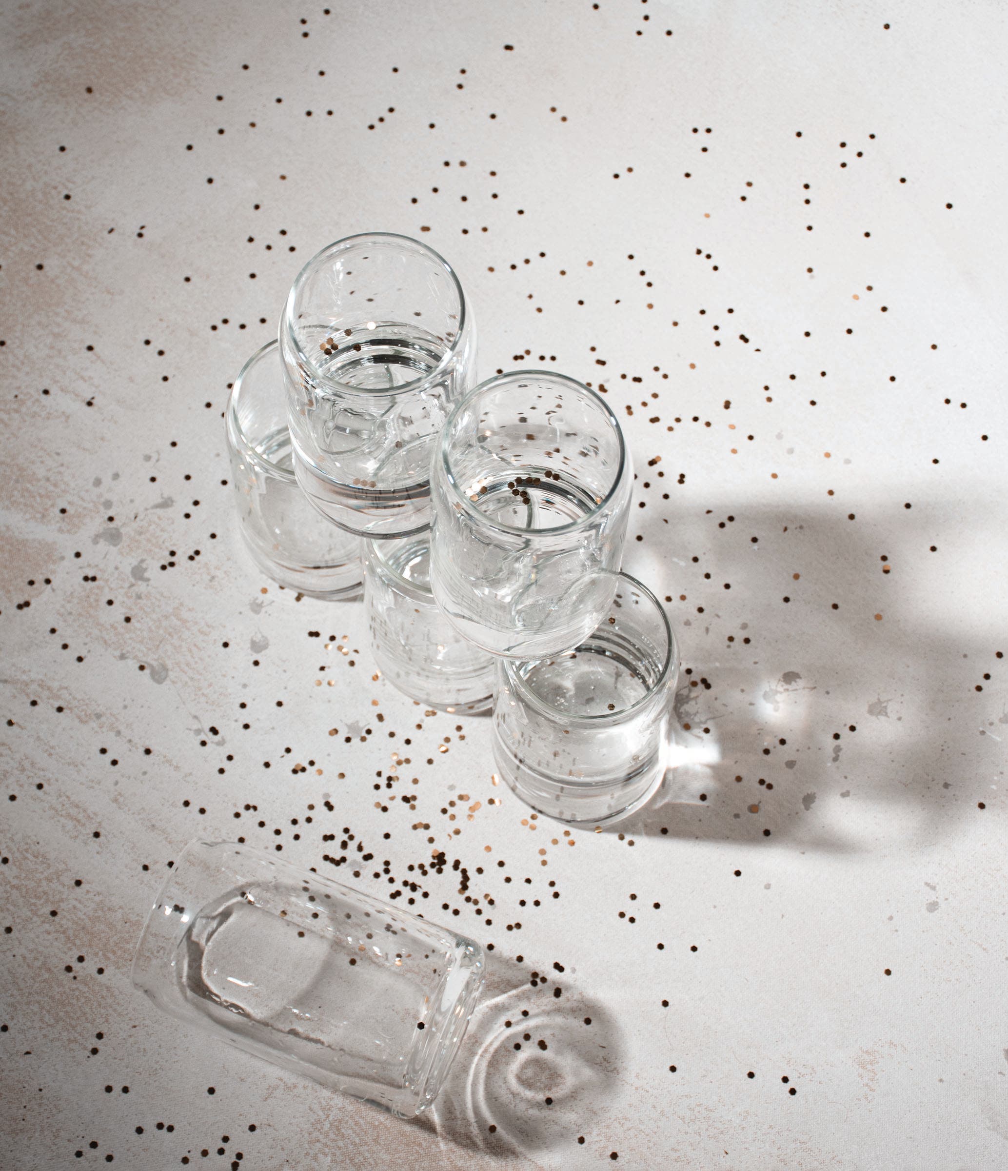 Empty glasses that look like beer cans with celebratory confetti