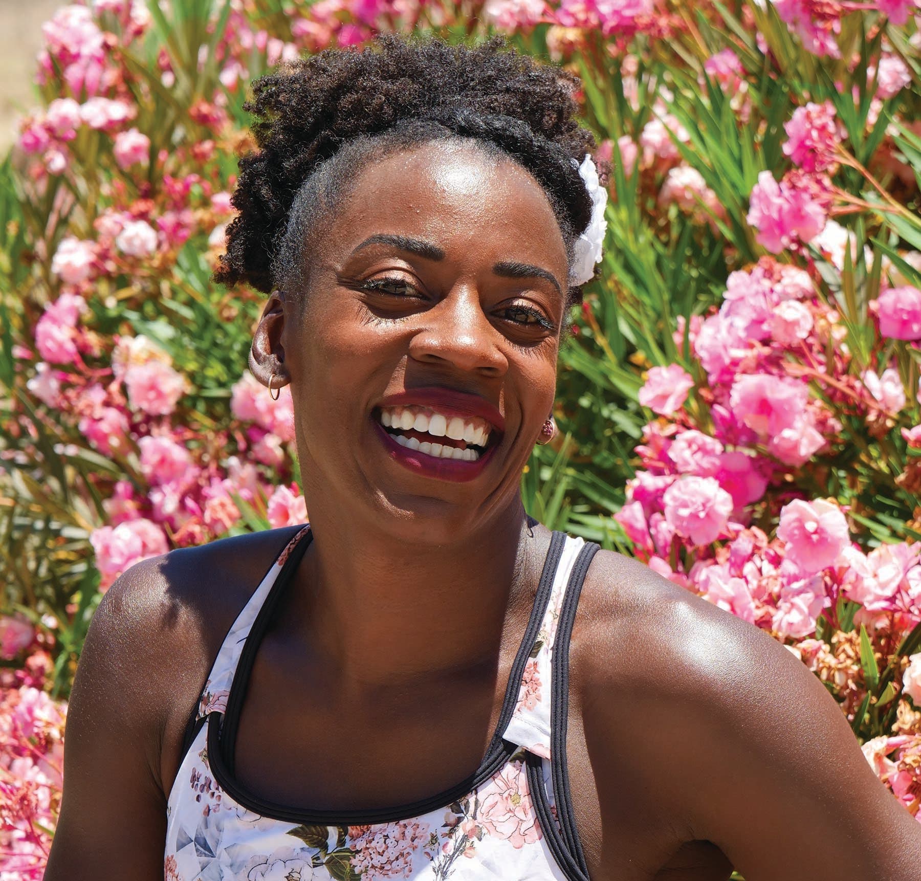 Alysia Montaño smiling with flowers in the background