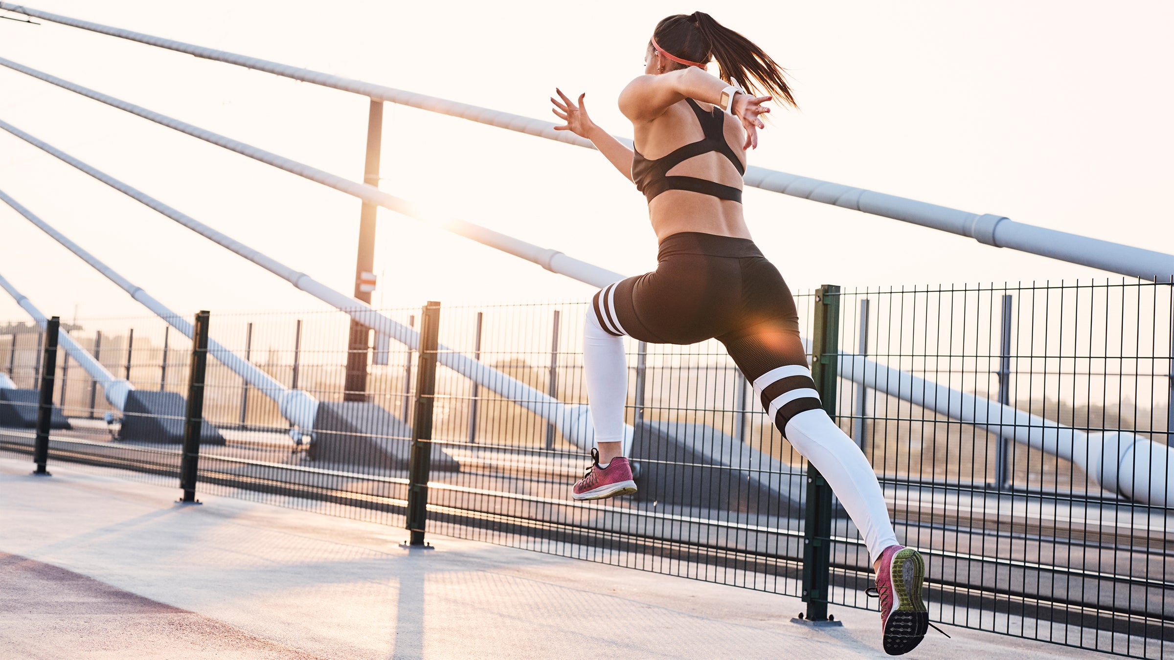 Woman doing bounding strides on a bridge