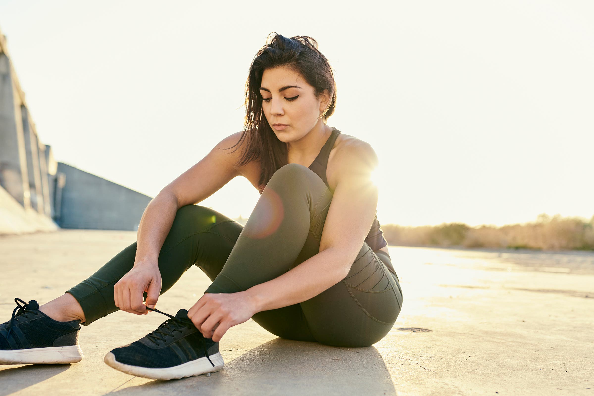 women tying her running shoes as she attempts to find her love of running again