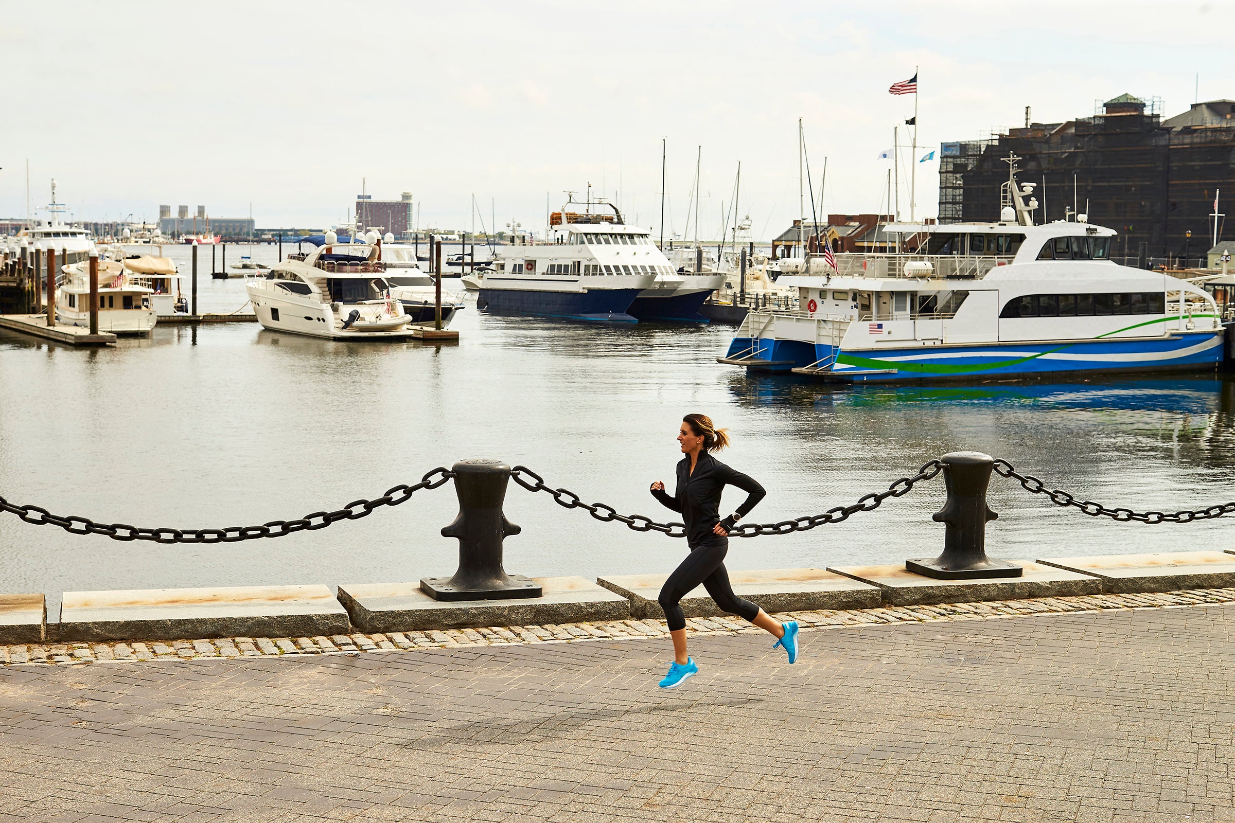 Woman running next to Boston harbor