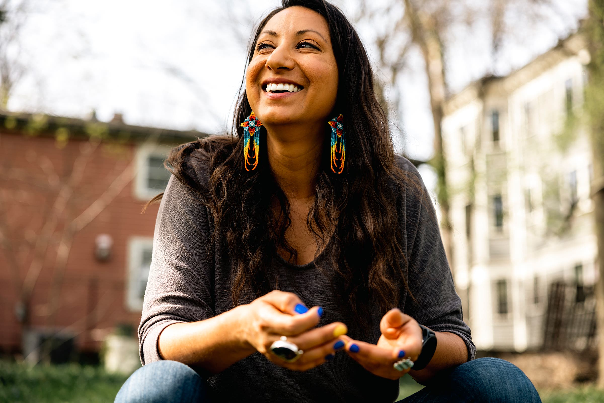Lydia Jennings of the Yoeme and Wixárika peoples smiling and wearing colorful earrings