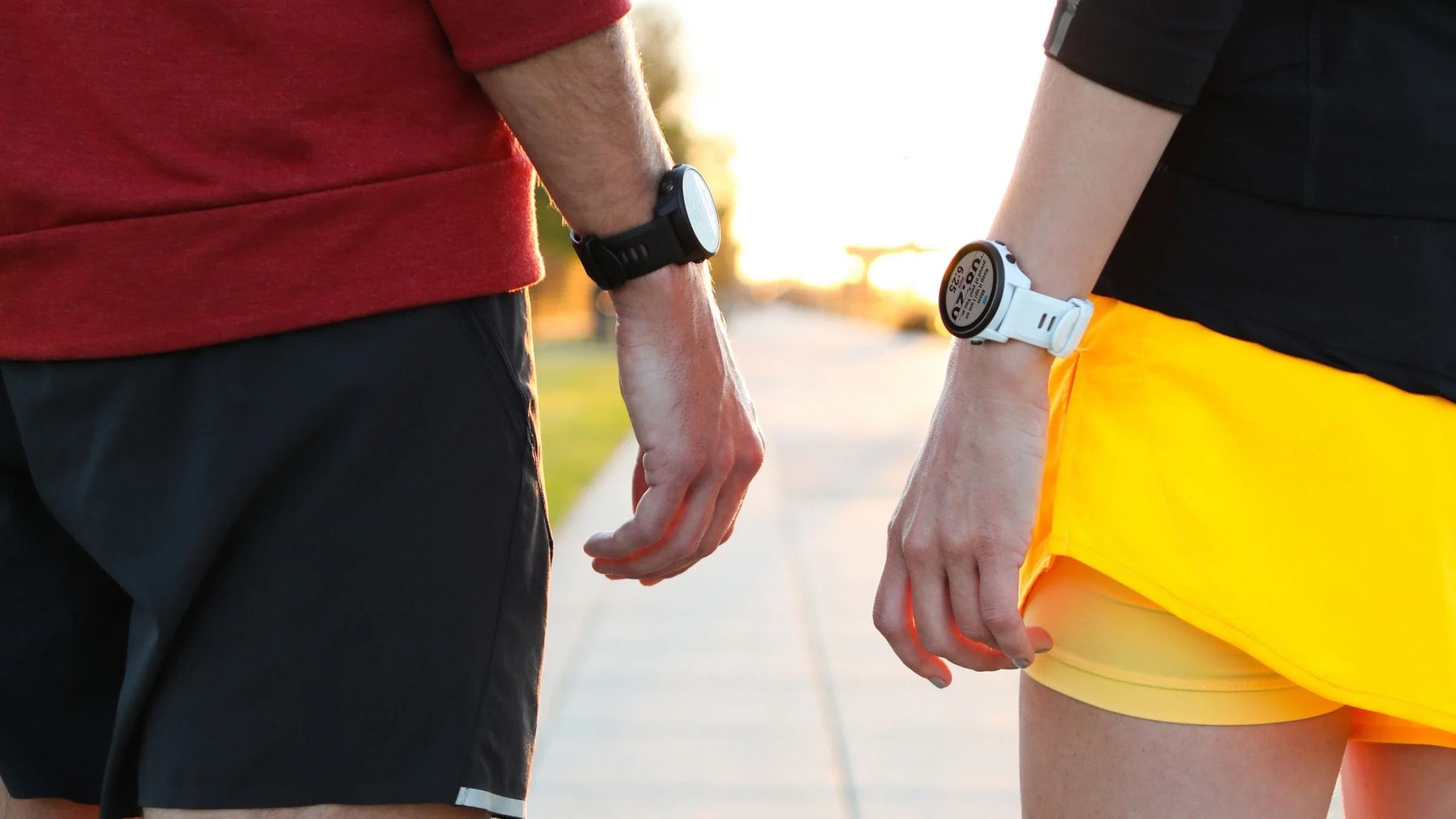 Running couple wearing GPS watches