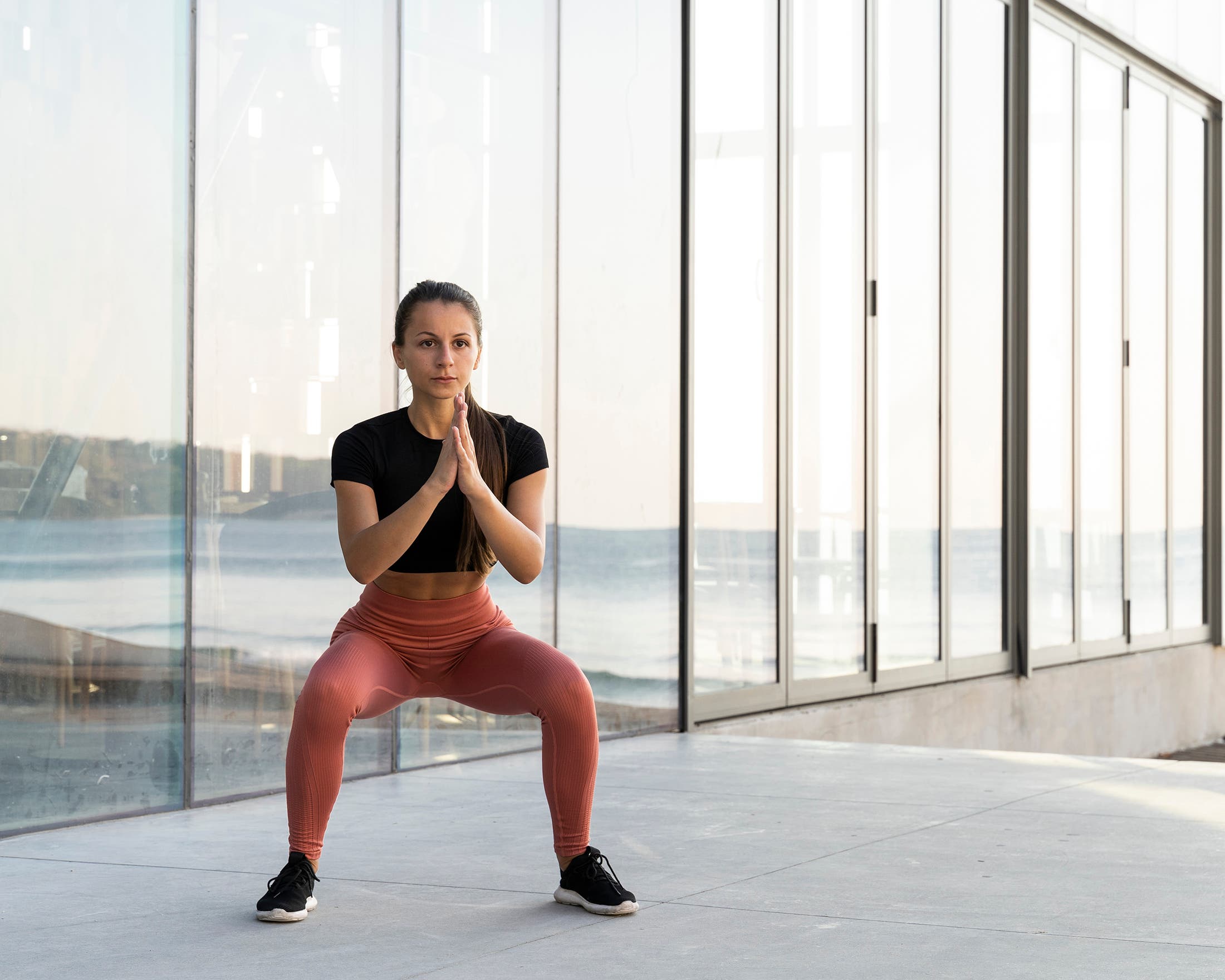 woman performing squat with weight centered at her chest