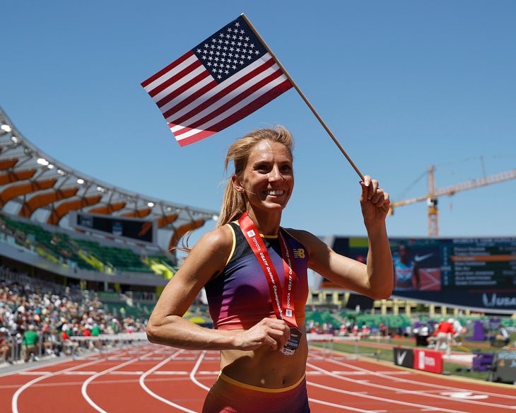 Cory McGee smiles while waving an American flag after placing second in the 1500m