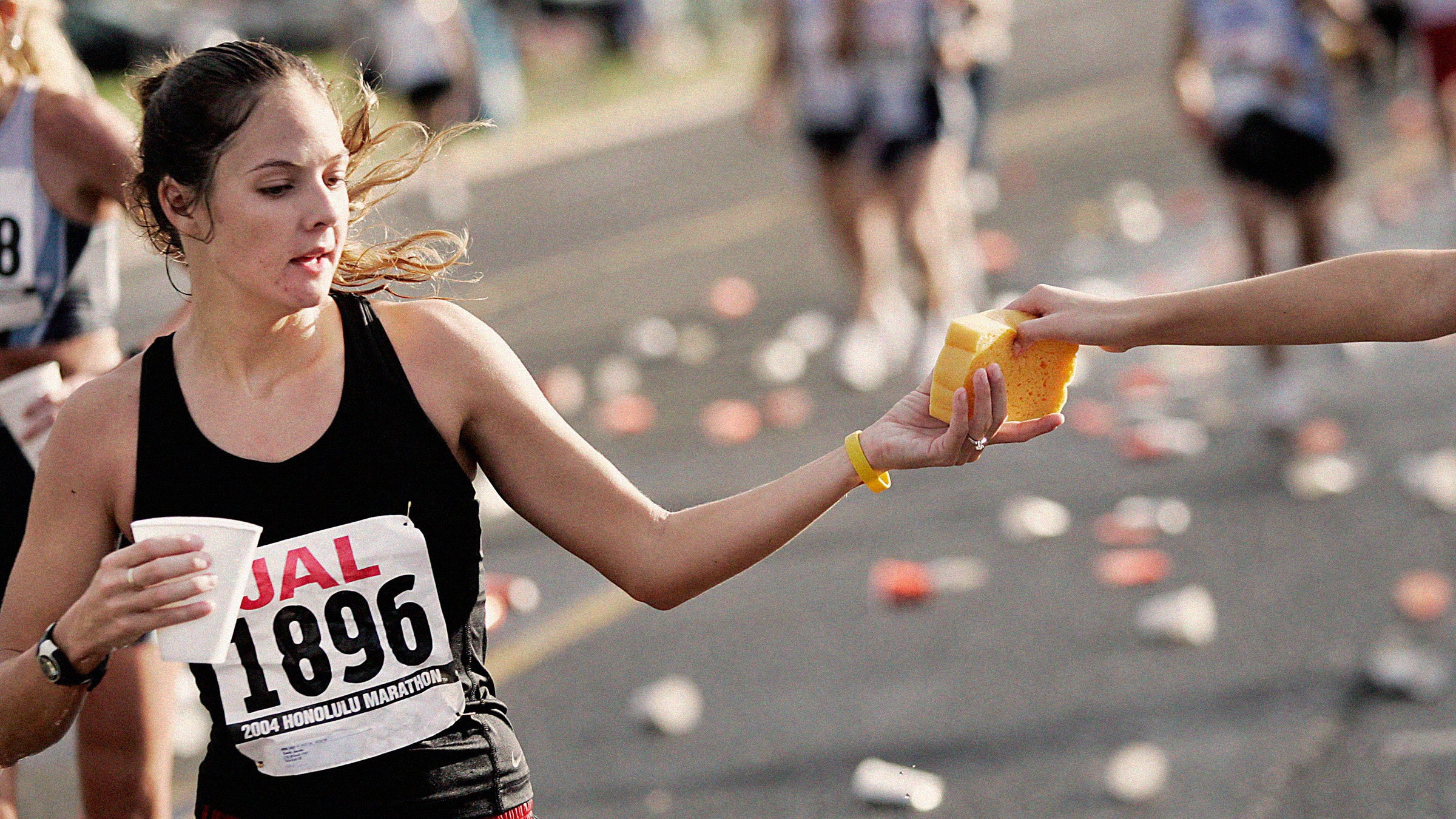 Runner grabs a wet sponge from an aid station during the final miles of the 2004 Honolulu Marathon December 12, 2004 in Honolulu, Hawaii.