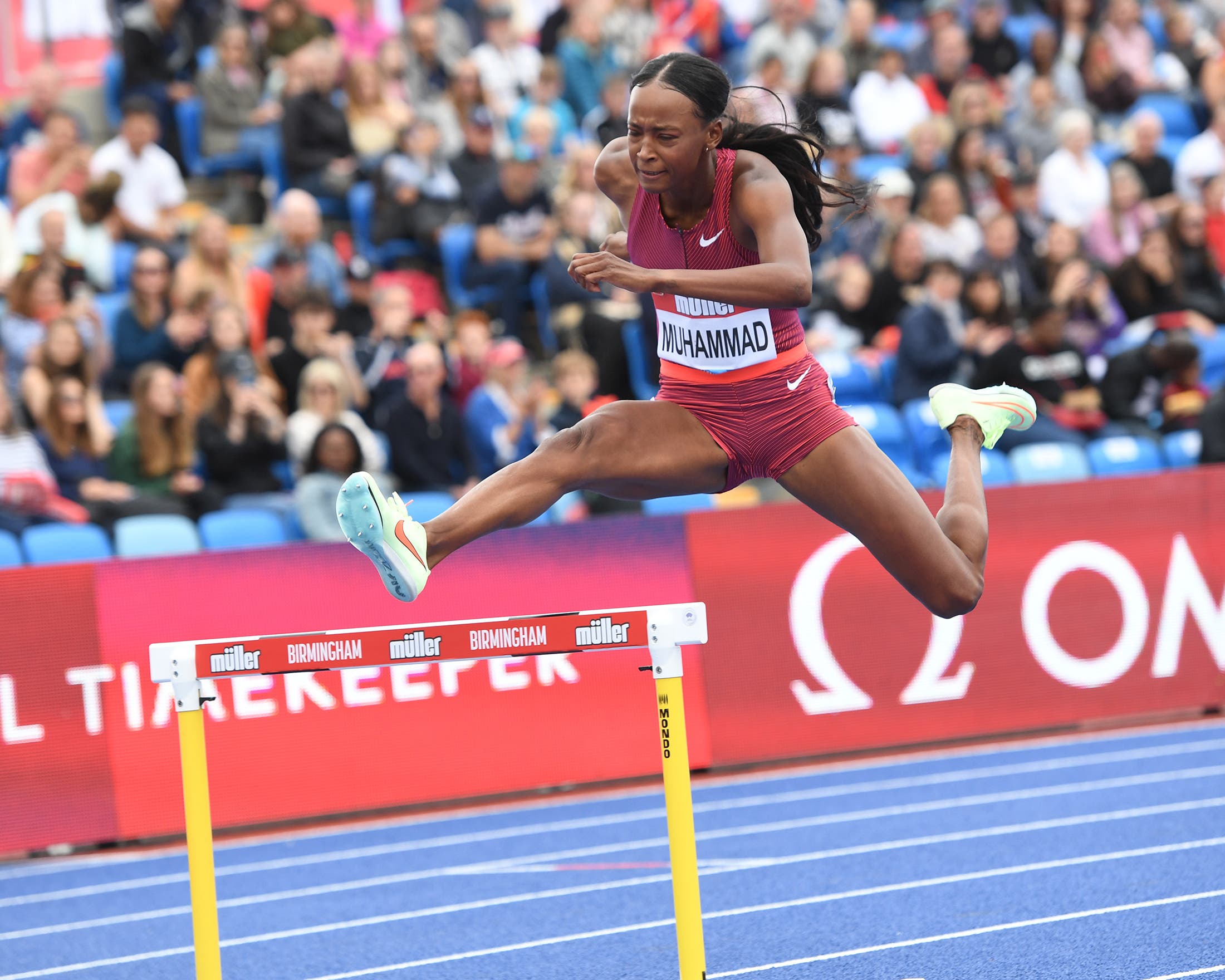 Dalilah Muhammad jumping over a hurdle