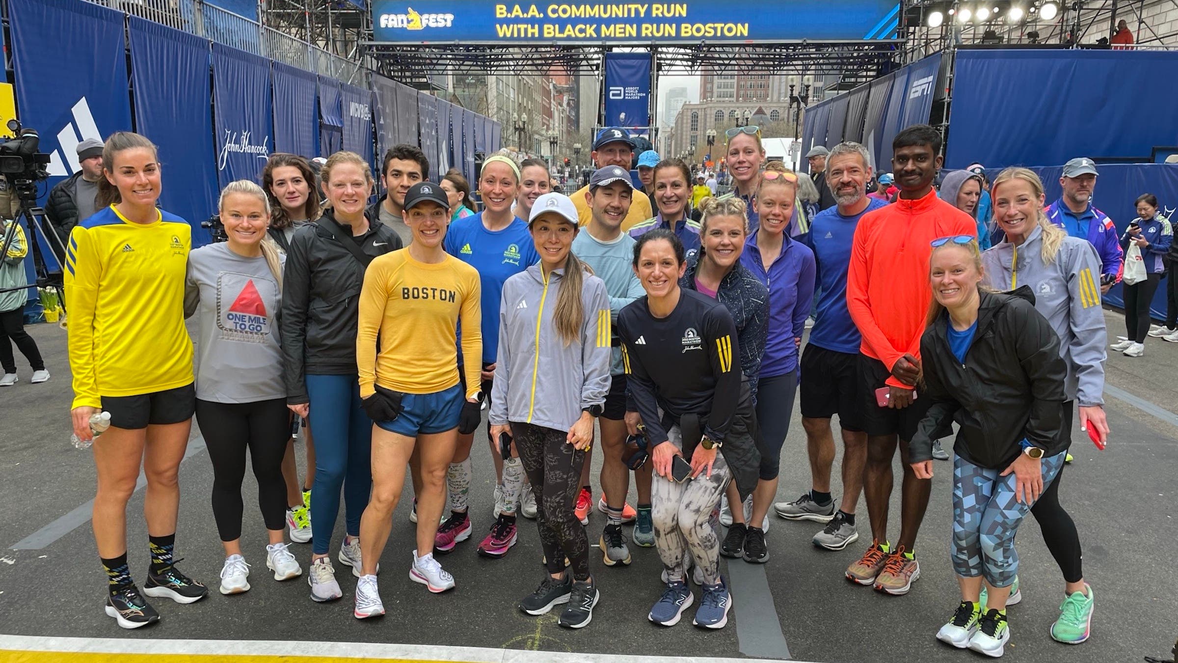 A group stands in front of the Boston Marathon finish line