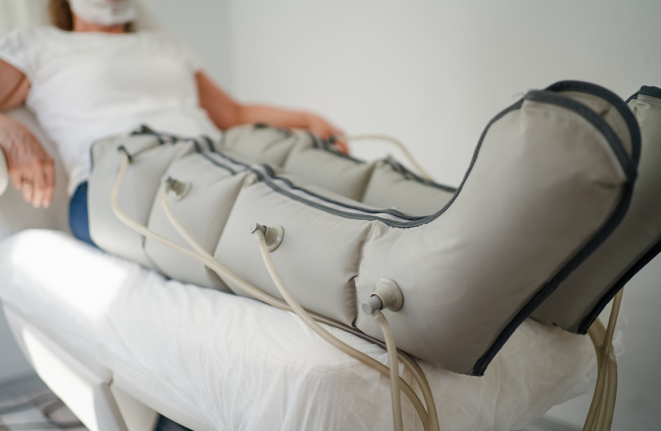 Woman lying in massaging suit at the spa clinic for the treatment of pressure therapy procedure