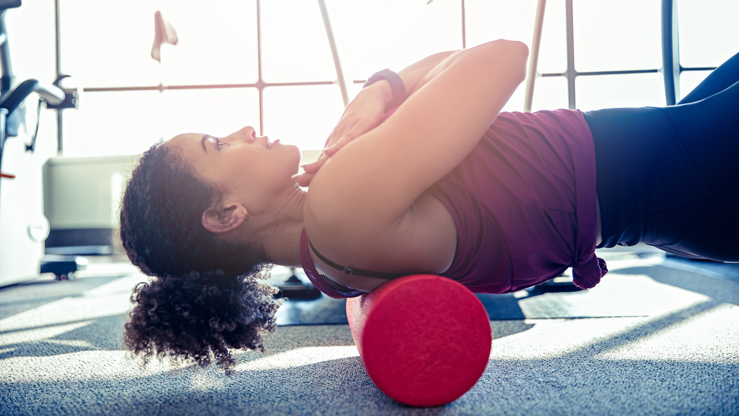 Woman stretching her back with a foam roller